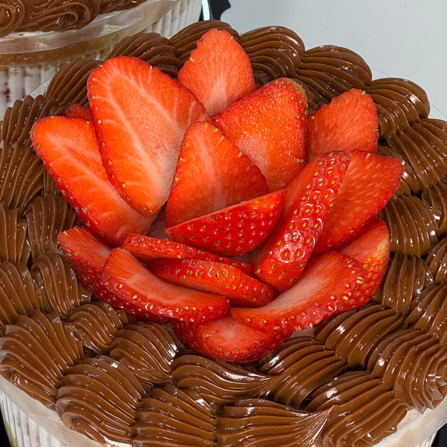 Pastel decorado con rosetones de dulce de leche y fresas frescas cortadas en flor. Ideal para detalles dulces o celebraciones especiales