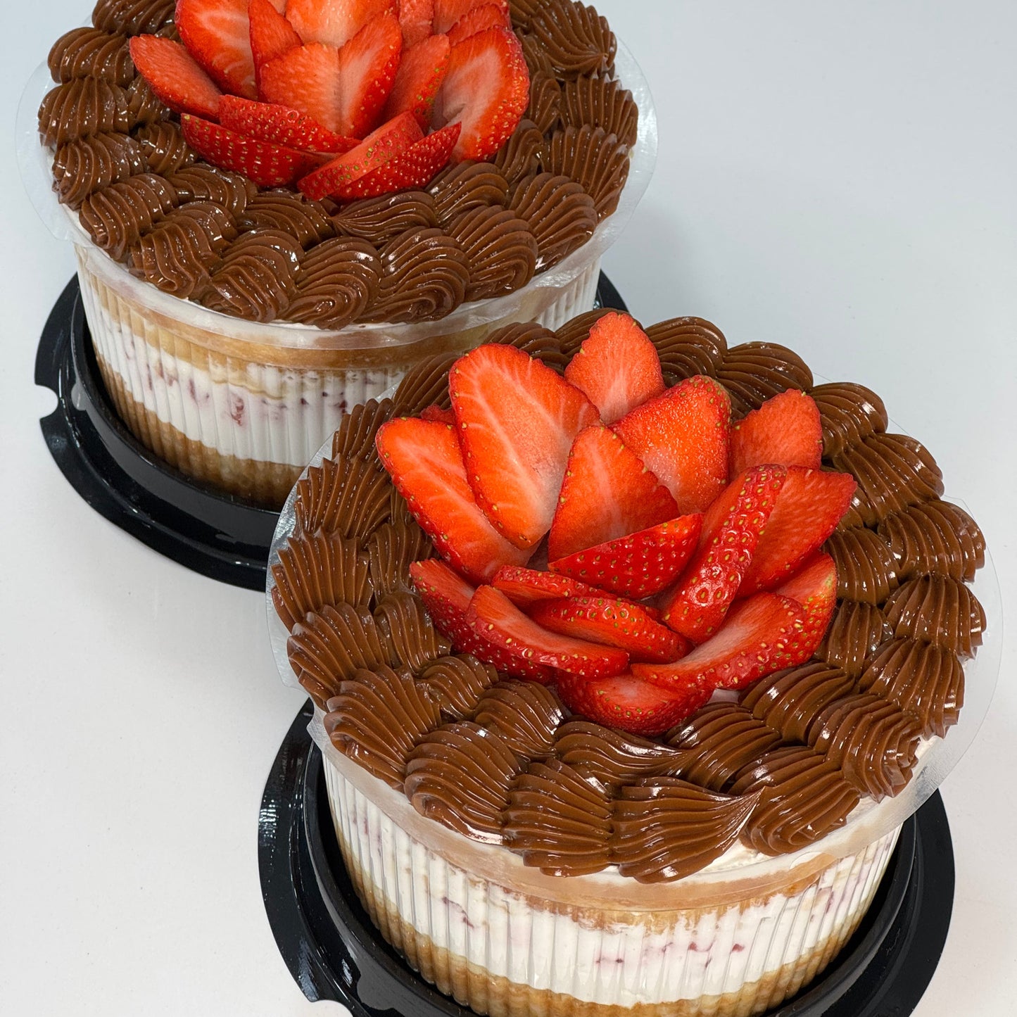 Mini tarta con base de bizcocho, crema blanca, fresas y rosetones de dulce de leche. Diseño elegante y artesanal de Nita’s Bakery.