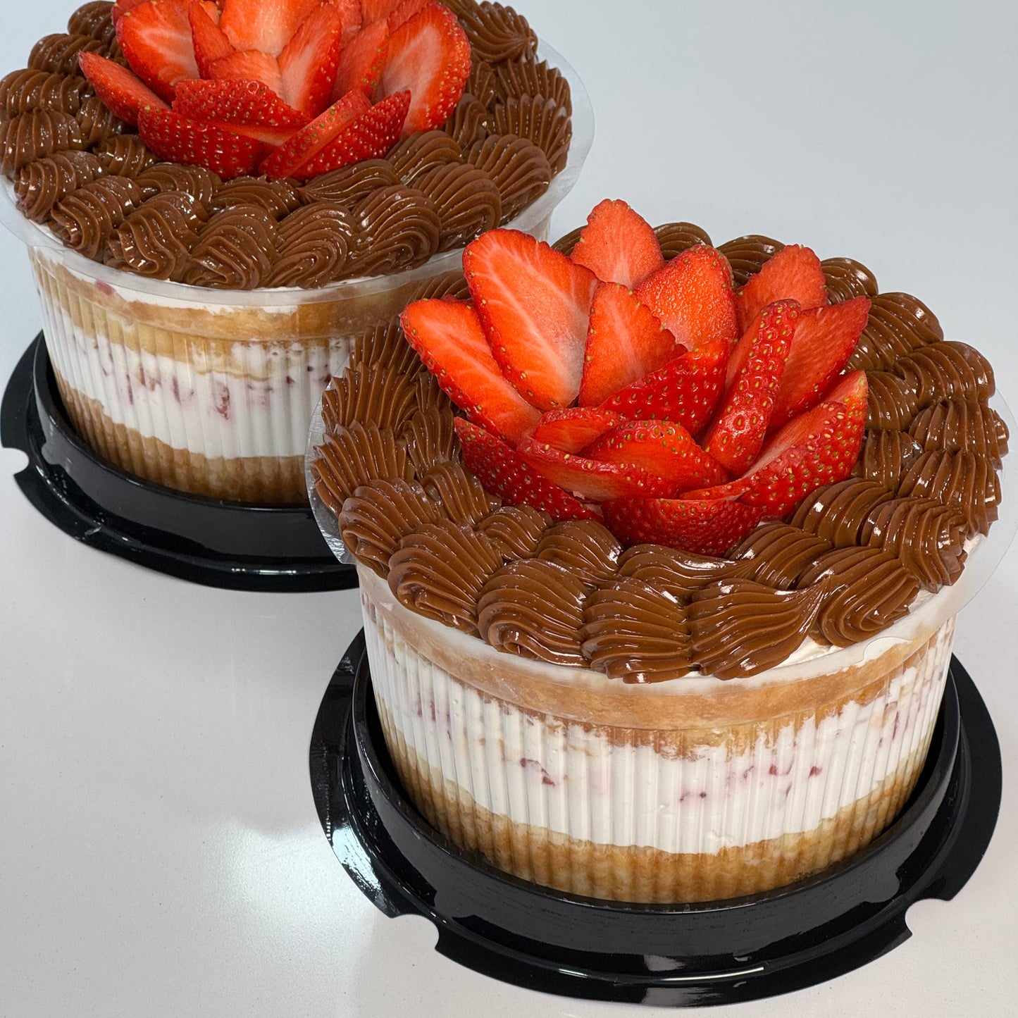 Tarta mini artesanal con crema chantilly, decoración de dulce de leche y fresas naturales en forma de flor. Postre individual perfecto para regalar o celebrar.